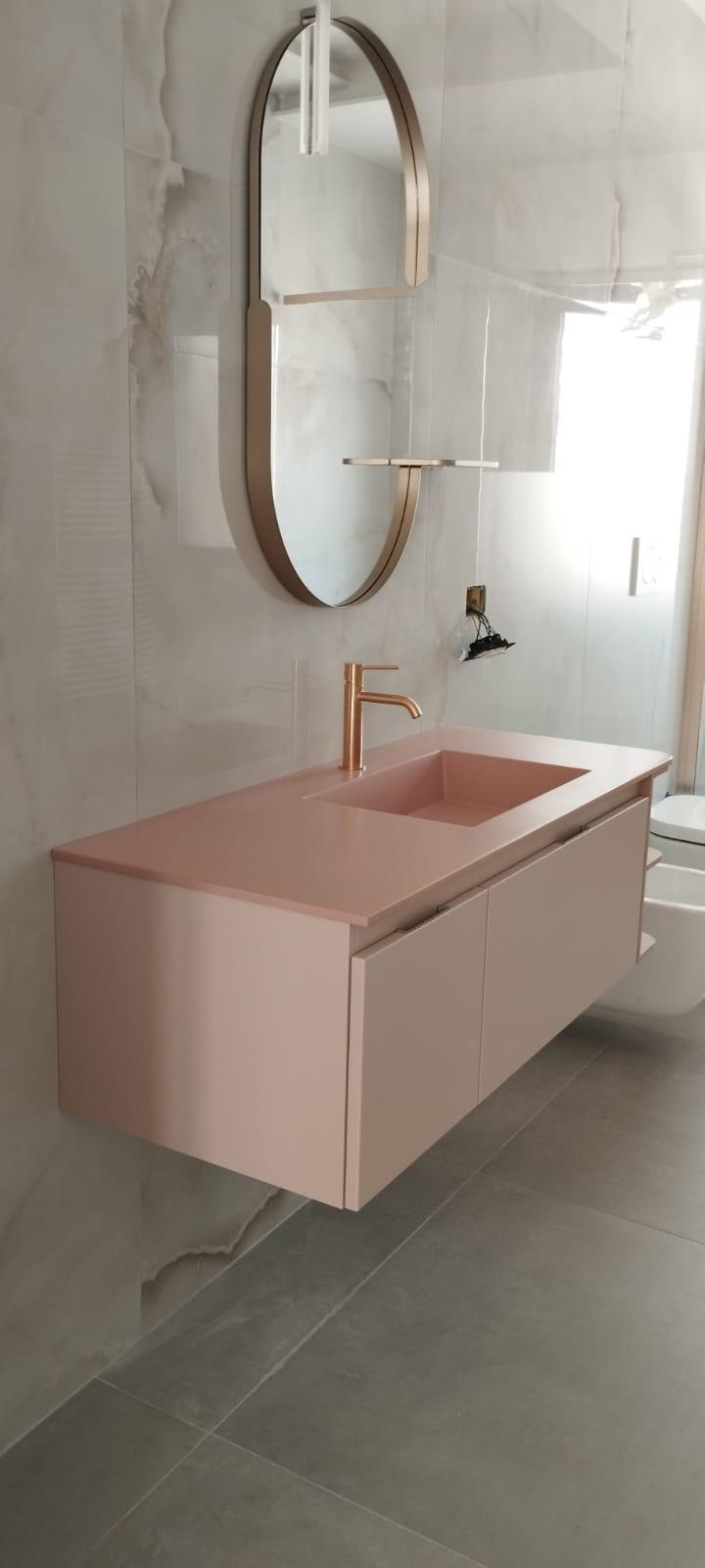 Bagno chiaro con mobile lavabo rosa e specchio ovale