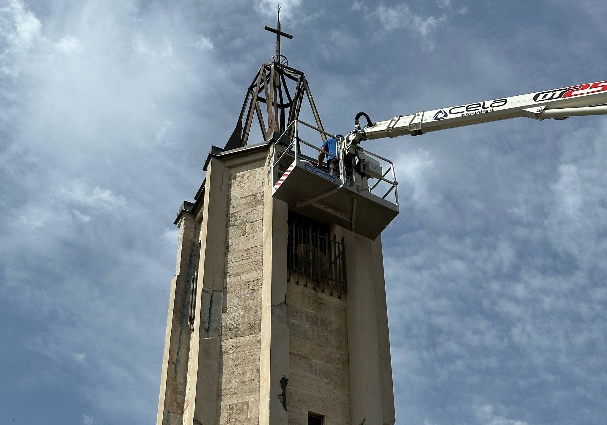 Piattaforma aerea presso torre con croce